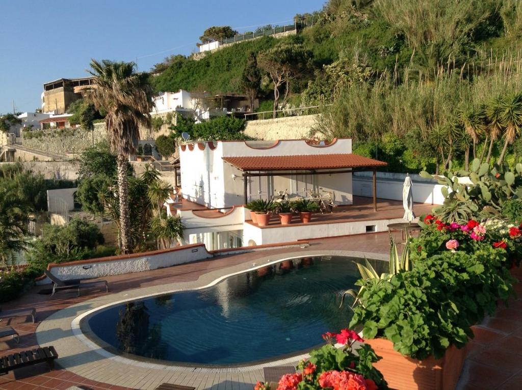 - une piscine en face d'une maison fleurie dans l'établissement Villa la Dimora di Zoè, à Ischia