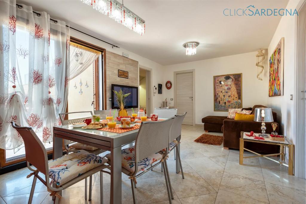 un salon avec une table, des chaises et un canapé dans l'établissement Alghero Villa Marlena with pool for exclusive use for 10 people, à Alghero