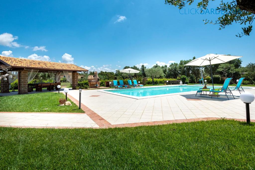 une piscine avec deux chaises et un parasol dans l'établissement Alghero Villa Marlena with pool for exclusive use for 10 people, à Alghero
