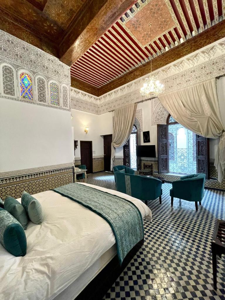 une chambre avec un lit, une table et des chaises dans l'établissement Le Grand Alcazar - Riad, à Fès 37 autres photos