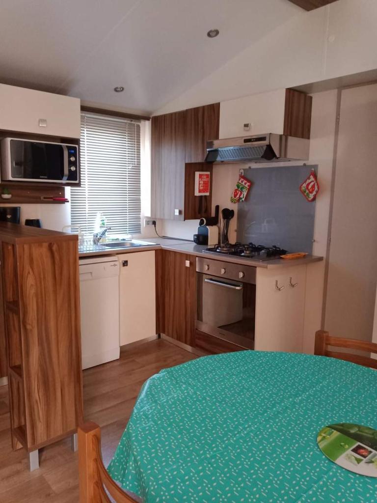 une cuisine avec une table et une cuisinière four supérieur dans l'établissement Mobilhome beaux volumes ES40, à Fréjus