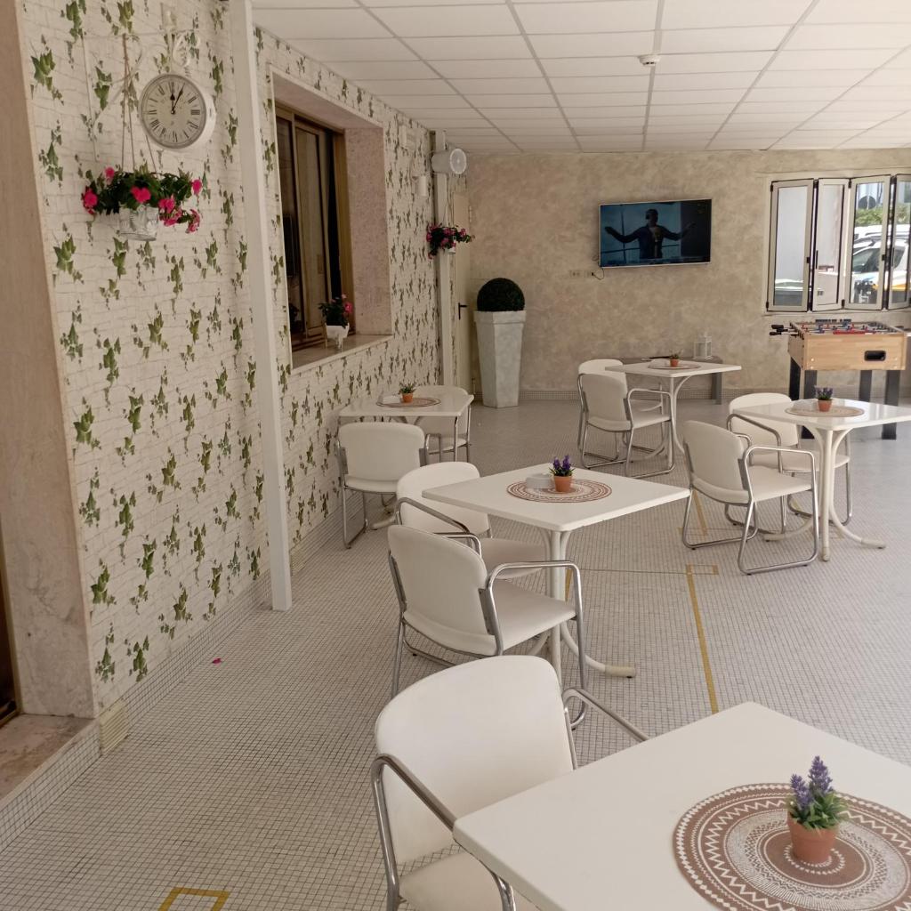 une salle à manger avec des tables et des chaises et une horloge au mur dans l'établissement Hotel Raul, à Riccione