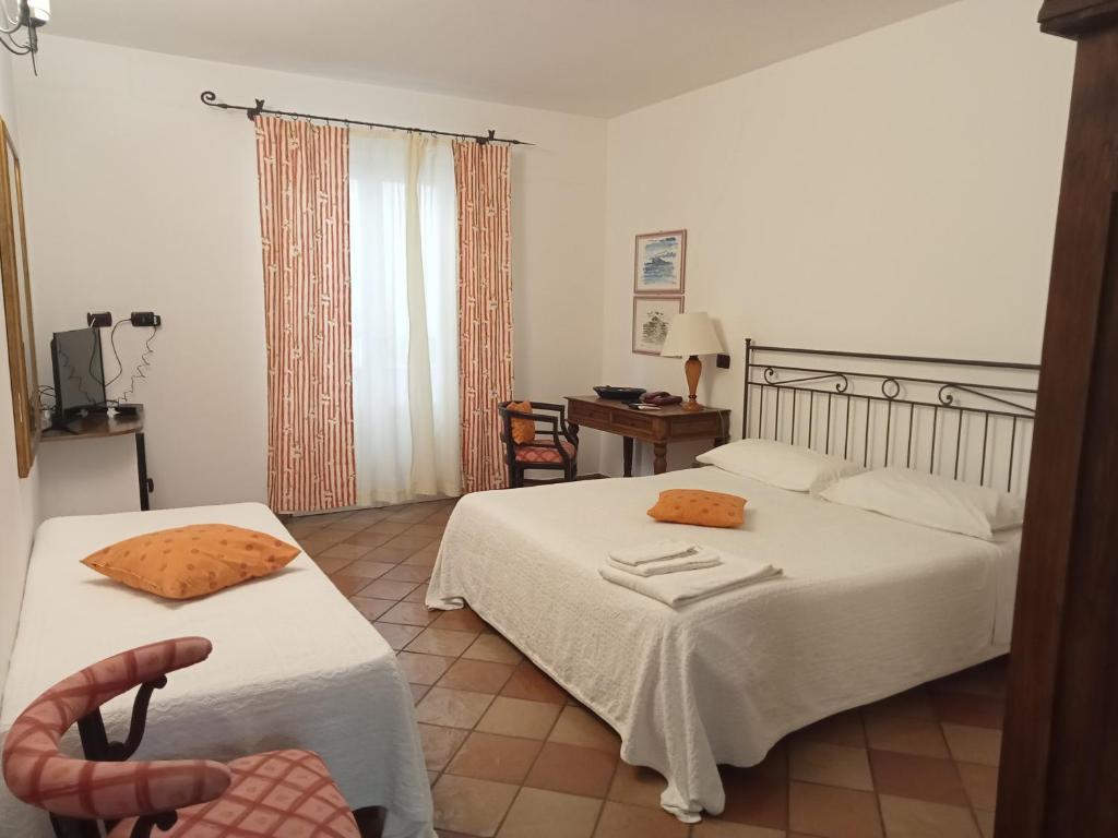 une chambre avec deux lits, un bureau et une chaise dans l'établissement Albergo Boutique Casajanca, à Canneto
