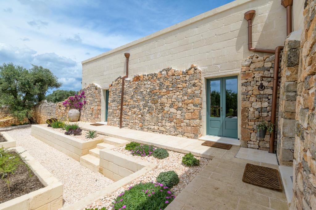 un bâtiment en pierre avec une porte bleue dans une cour dans l'établissement Nido Maremonte, à Ostuni