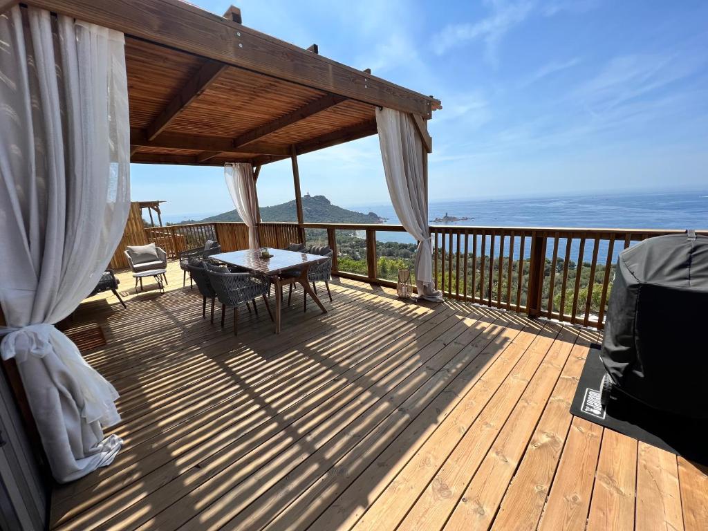 une terrasse en bois avec une table et des chaises dessus dans l'établissement Mobile Evasion okpl BEAUVOIR, à Saint-Raphaël