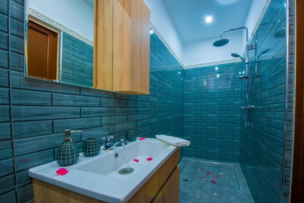 une salle de bain avec un lavabo et une douche dans l'établissement Riad Amely, à Marrakech
