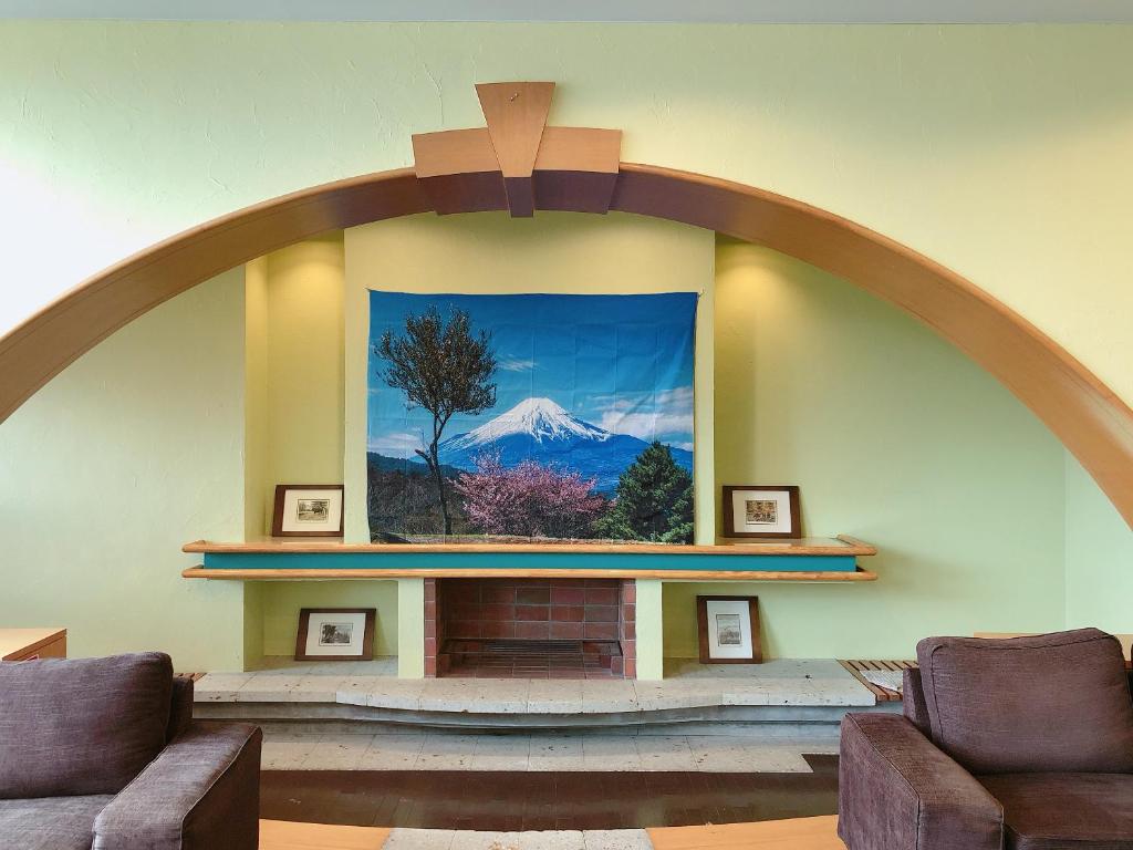 Cette chambre dispose d'une cheminée avec une photo de montagne. dans l'établissement Breezbay Lake Resort Kawaguchiko, à Fujikawaguchiko