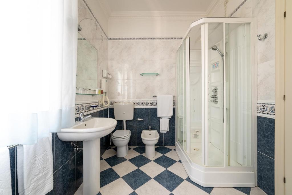 une salle de bain avec un lavabo, des toilettes et une douche dans l'établissement La Dépendance by Casa Bianca, à Lido di Jesolo