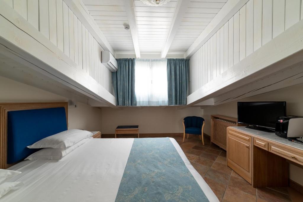 - une grande chambre avec un grand lit et une télévision dans l'établissement La Dépendance by Casa Bianca, à Lido di Jesolo