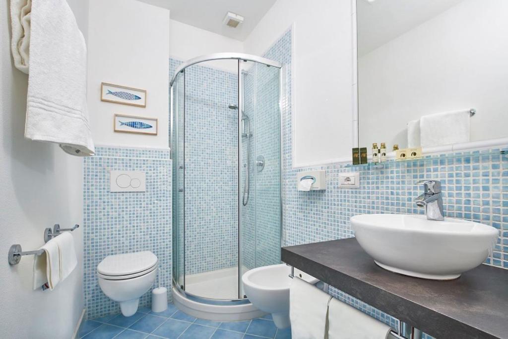 une salle de bain avec un lavabo, des toilettes et une douche dans l'établissement Hotel Antares, à Capoliveri 37 autres photos