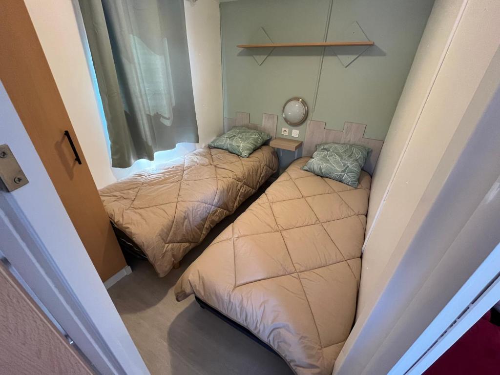 deux lits dans une petite pièce avec une fenêtre dans l'établissement Mobile home camping Pedro, au Grau-dʼAgde