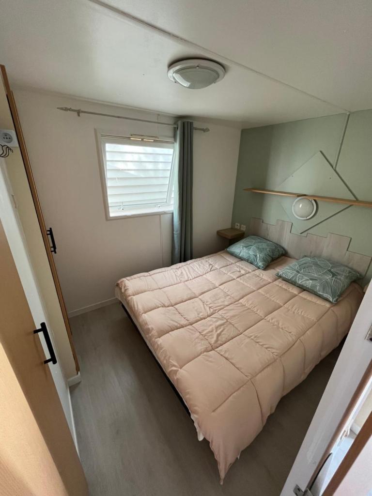 une chambre avec un grand lit et une fenêtre dans l'établissement Mobile home camping Pedro, au Grau-dʼAgde