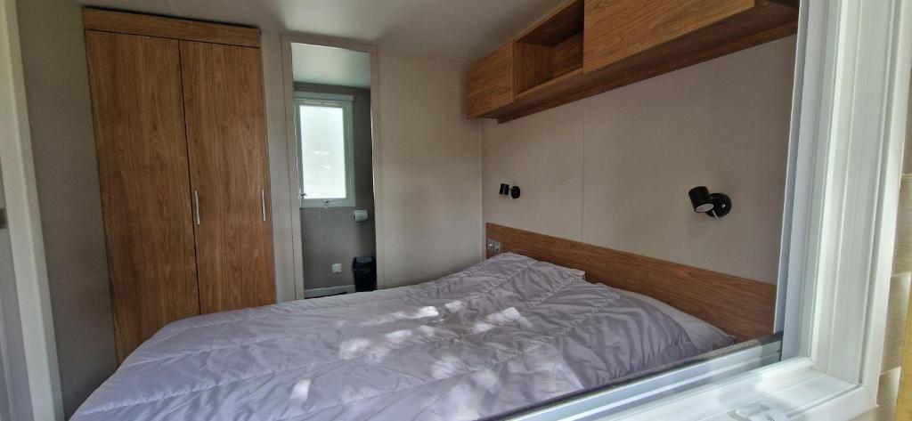 une petite chambre avec un lit et une fenêtre dans l'établissement Mobilhome 6P Camping la Carabasse Vias, à Vias 16 autres photos