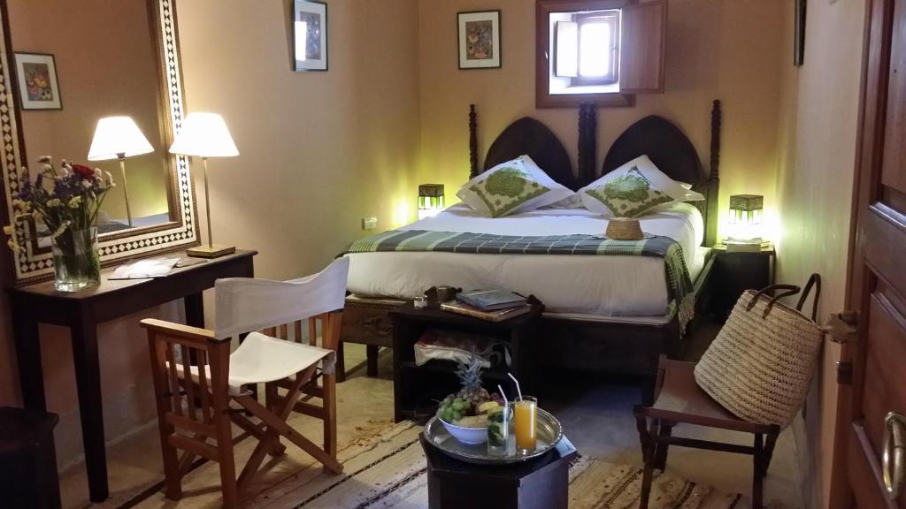 une chambre d'hôtel avec un lit, une table et des chaises dans l'établissement Riad Al Ksar & Spa, à Marrakech 37 autres photos