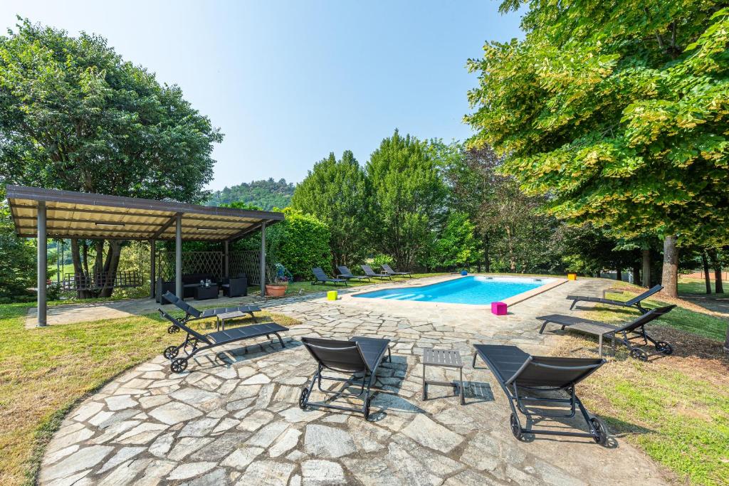un patio avec des chaises et une piscine dans l'établissement Villa Cornelia , entire Villa with private pool, à Corneliano d'Alba