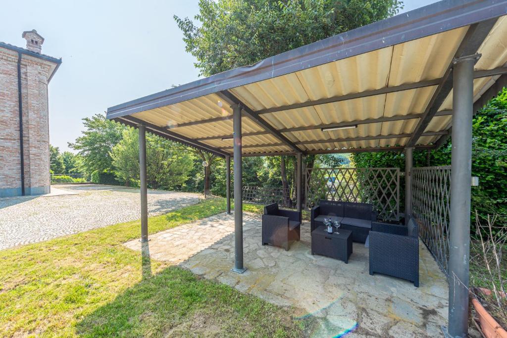un pavillon en bois avec des chaises bleues en dessous dans l'établissement Villa Cornelia , entire Villa with private pool, à Corneliano d'Alba