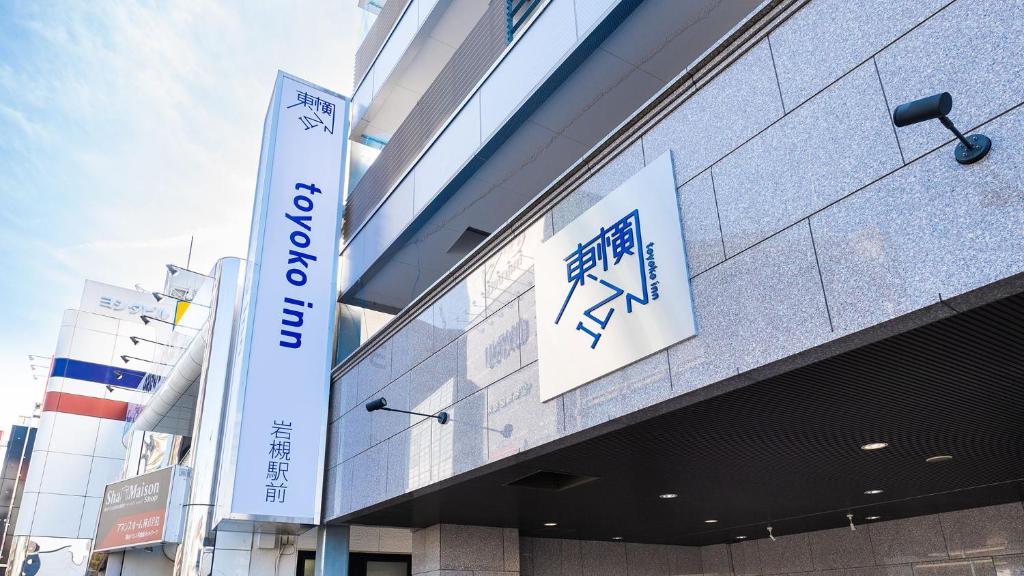 un bâtiment avec une enseigne sur le côté dans l'établissement Toyoko Inn Saitama Iwatsuki Ekimae, à Saitama