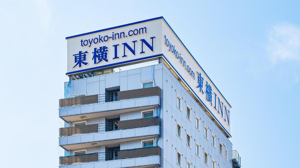 un bâtiment avec une enseigne au sommet dans l'établissement Toyoko Inn Saitama Iwatsuki Ekimae, à Saitama 36 autres photos