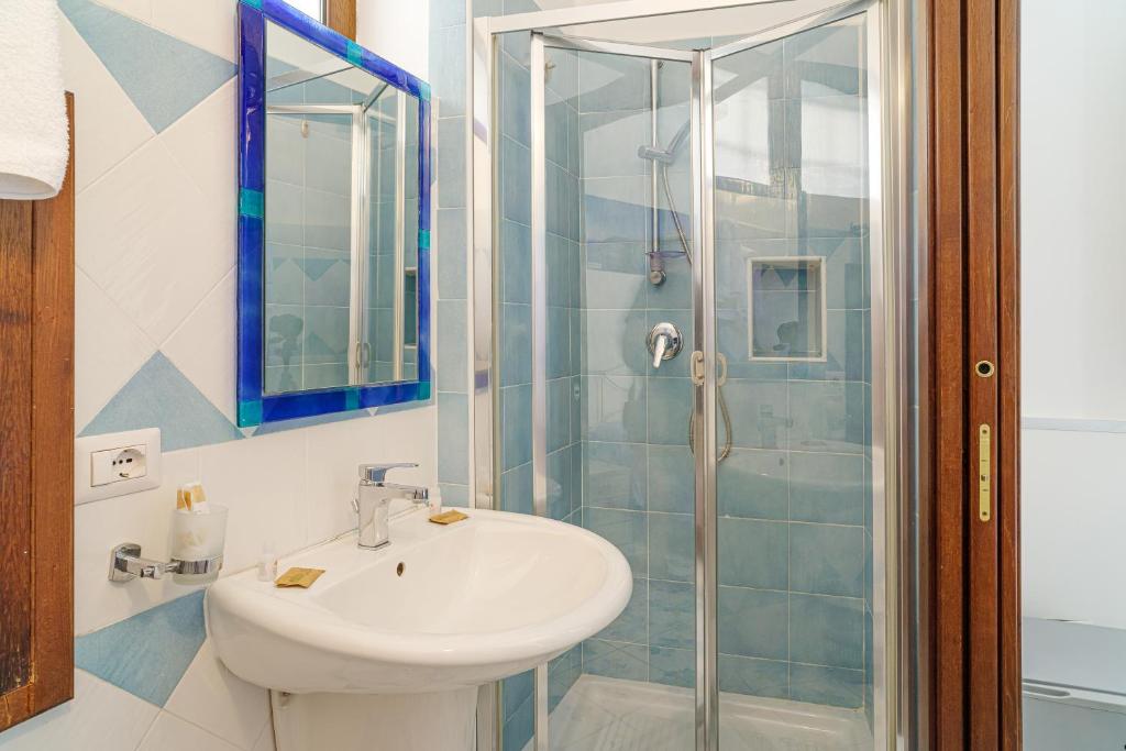 une salle de bain avec un lavabo et une douche dans l'établissement Hotel La Marina, à Santa Maria di Castellabate