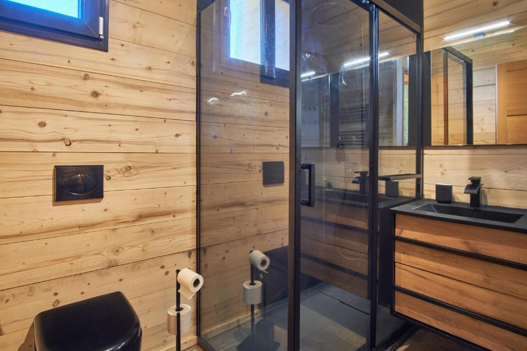 une salle de bain avec un lavabo et une douche en verre dans l'établissement Chalet le Lys Martagon, à Saint-Pierre-dʼEntremont