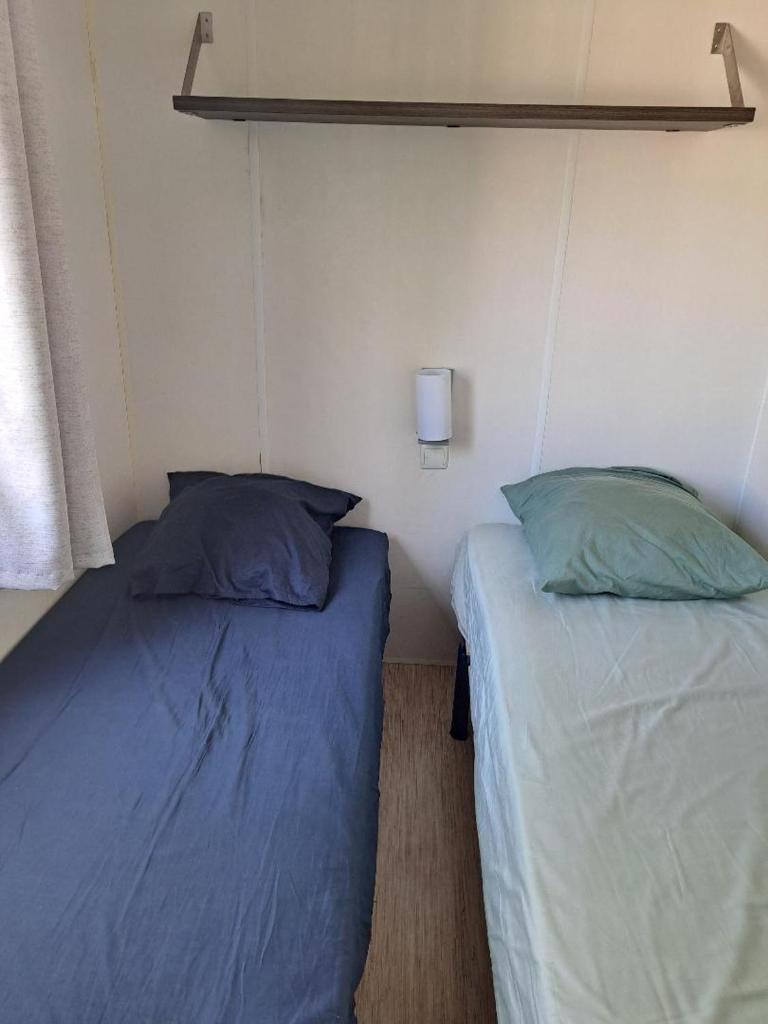 - 2 lits dans une chambre avec 2 oreillers dans l'établissement Mobil Home Domaine des Iscles, à La Roque-dʼAnthéron 2 autres photos