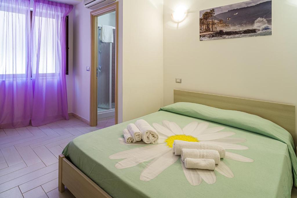 - une chambre avec un lit, des serviettes et une fleur dans l'établissement Hotel La Marina, à Santa Maria di Castellabate