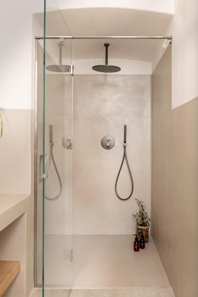 une douche avec une porte vitrée dans une salle de bain dans l'établissement Masseria Auraterrae, à Polignano a Mare 150 autres photos