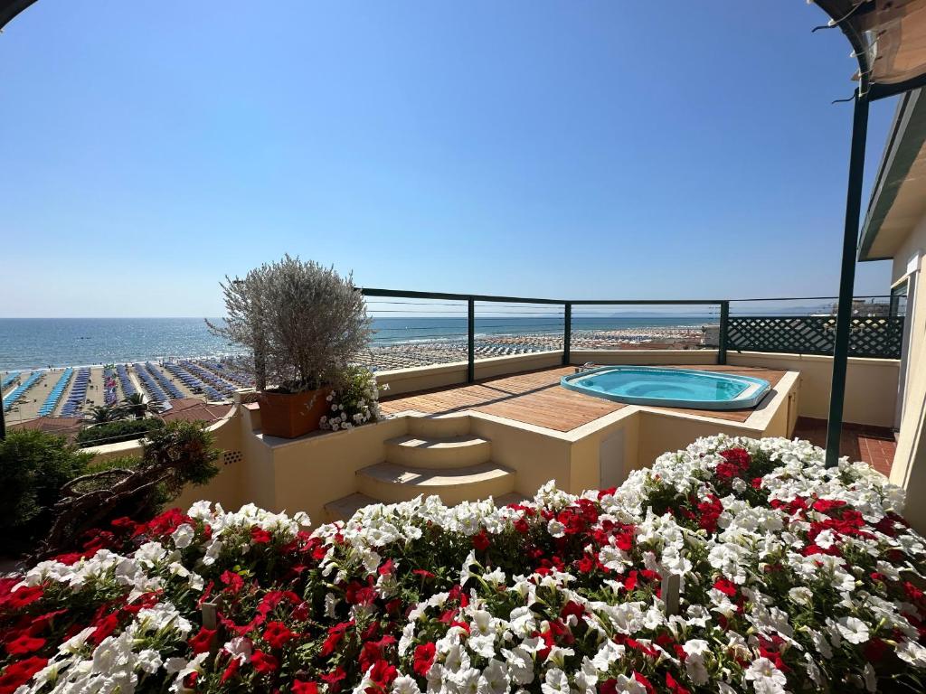 - un balcon avec une piscine et des fleurs dans l'établissement Piccadilly Penthouse with Jacuzzi, à Lido di Camaiore