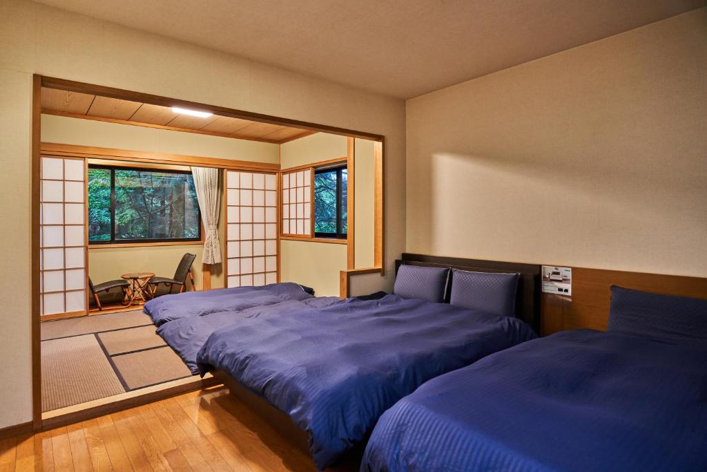 une chambre avec deux lits et une fenêtre dans l'établissement Ajisai Onsen Ryokan - Award Winning Private Open Air Onsen, à Hakone 37 autres photos