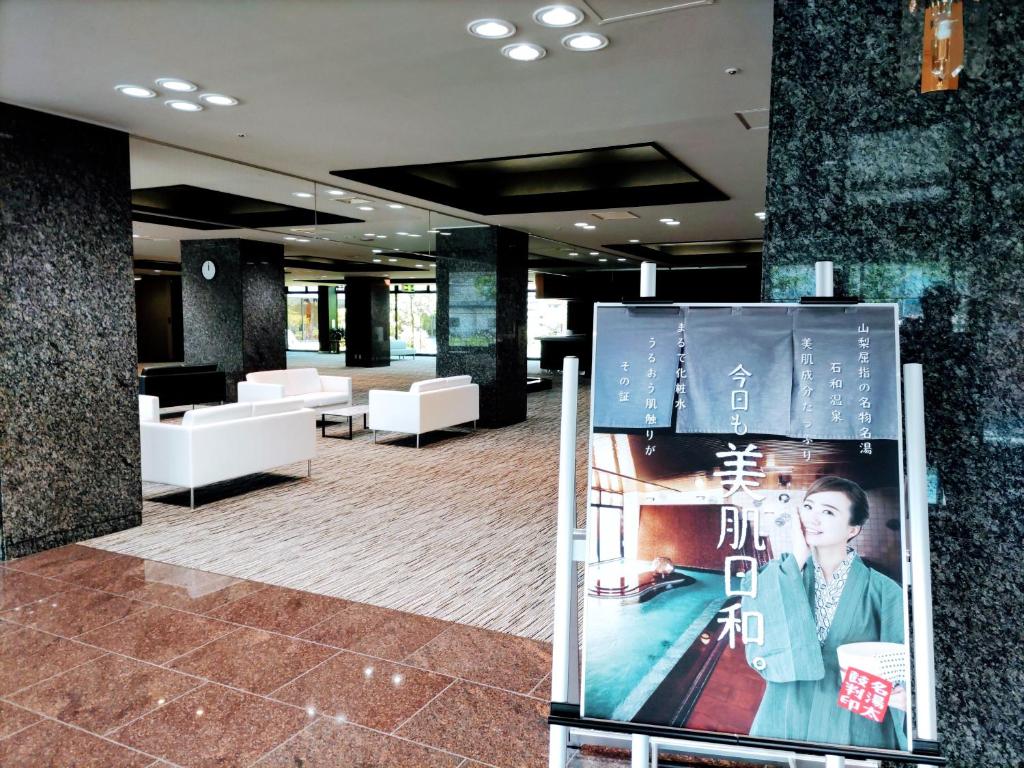 un hall avec un panneau au milieu d'un bâtiment dans l'établissement 楽気ハウス甲斐路 Raki House KAIJI, à Fuefuki