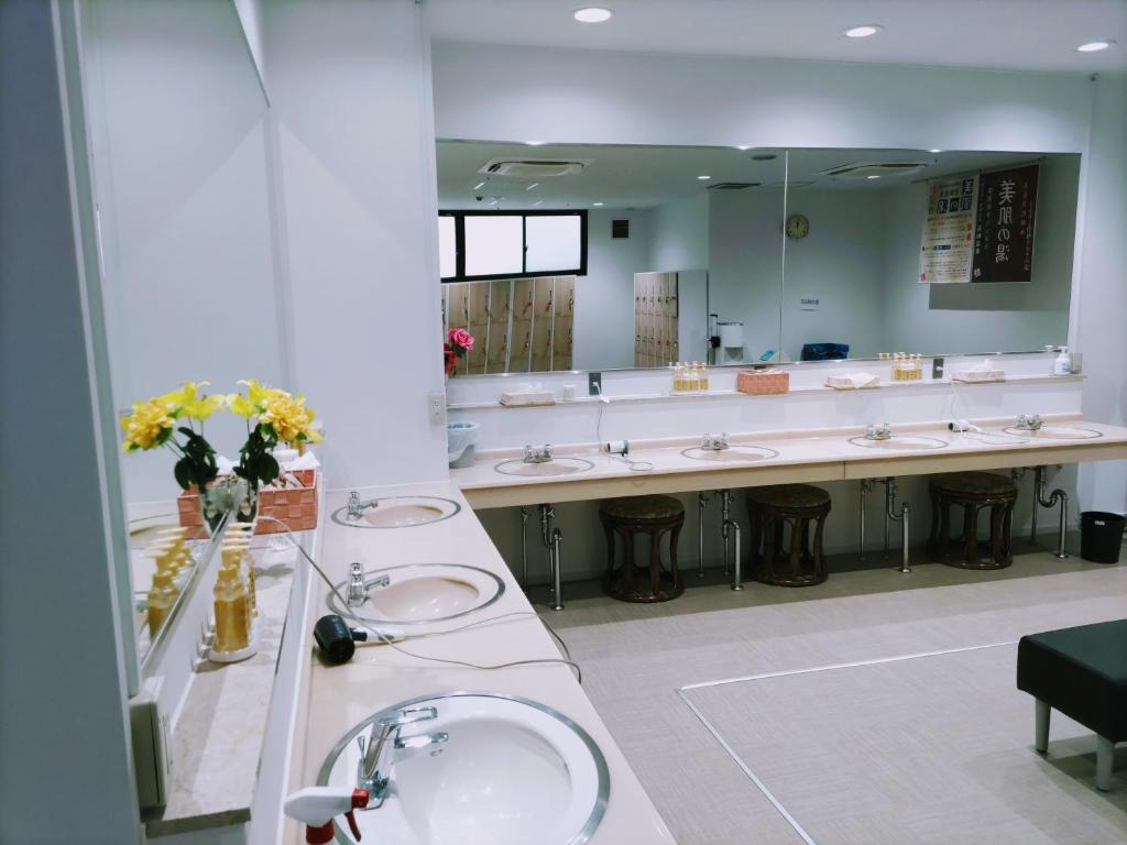 La salle de bains est pourvue de 3 lavabos et d'un grand miroir. dans l'établissement 楽気ハウス甲斐路 Raki House KAIJI, à Fuefuki