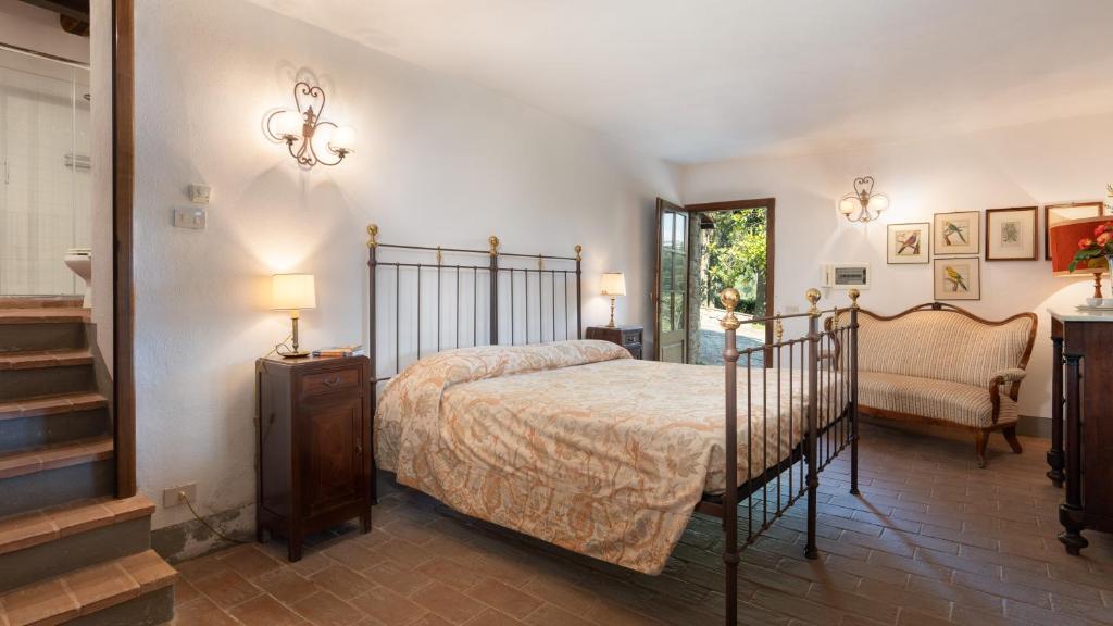 - une chambre avec un lit, une chaise et un escalier dans l'établissement Crognole 6, Emma Villas, à Radda in Chianti