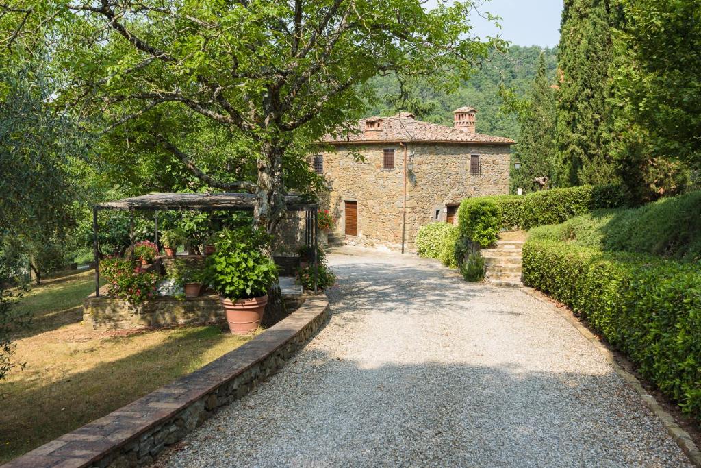 une maison en pierre avec un arbre et une allée dans l'établissement Crognole 6, Emma Villas, à Radda in Chianti