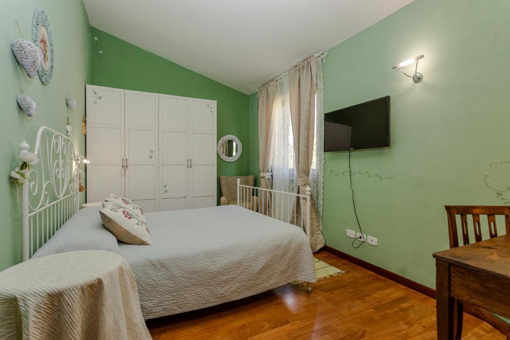 - une chambre avec des murs verts, un lit et une table dans l'établissement Villa Lolù, à Terranuova Bracciolini 99 autres photos