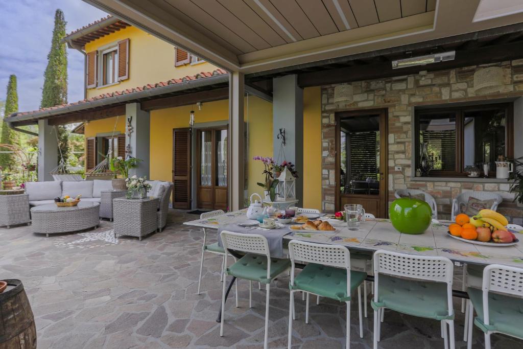 une terrasse extérieure avec une table et des chaises avec des fruits dessus dans l'établissement Villa Lolù, à Terranuova Bracciolini