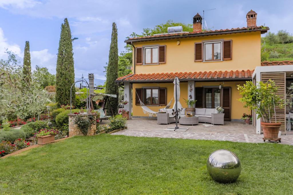 une maison jaune avec une cour avec une balle dans la cour dans l'établissement Villa Lolù, à Terranuova Bracciolini