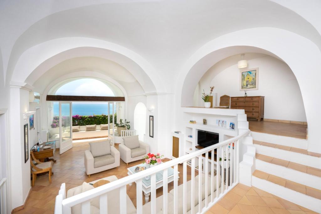 - un salon avec des murs blancs et un escalier dans l'établissement Villa Marilu Praiano, à Praiano