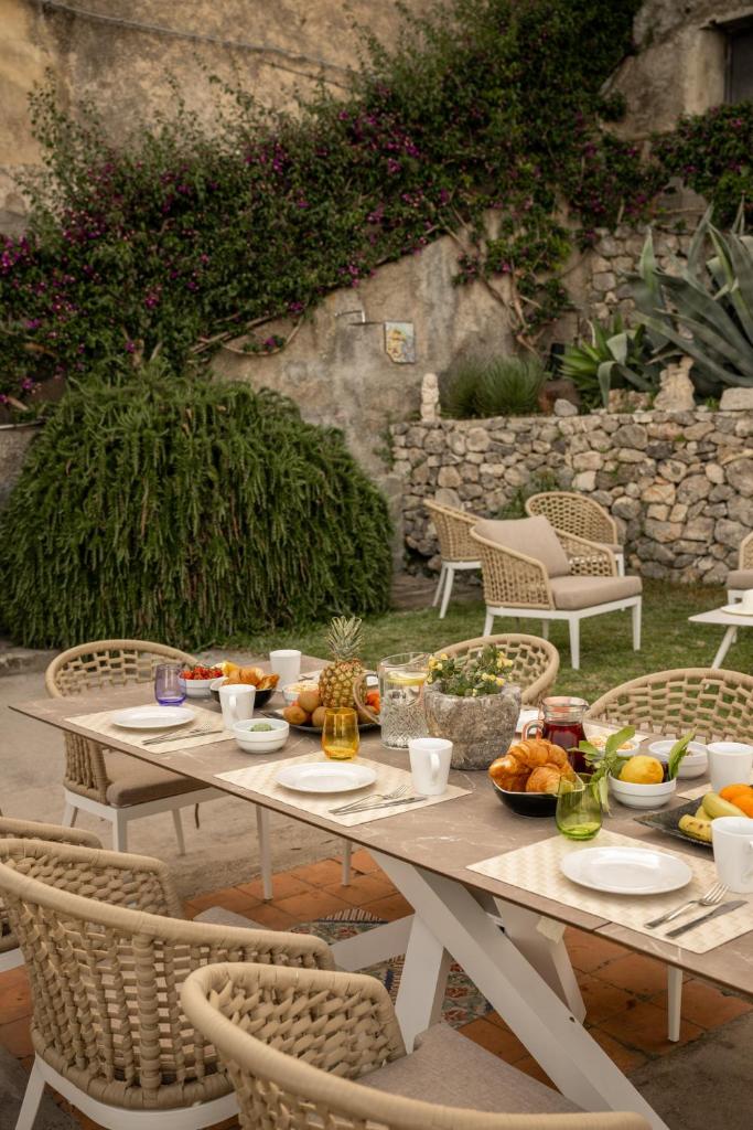 - une table de pique-nique avec de la nourriture et des chaises dans l'établissement Villa Marilu Praiano, à Praiano