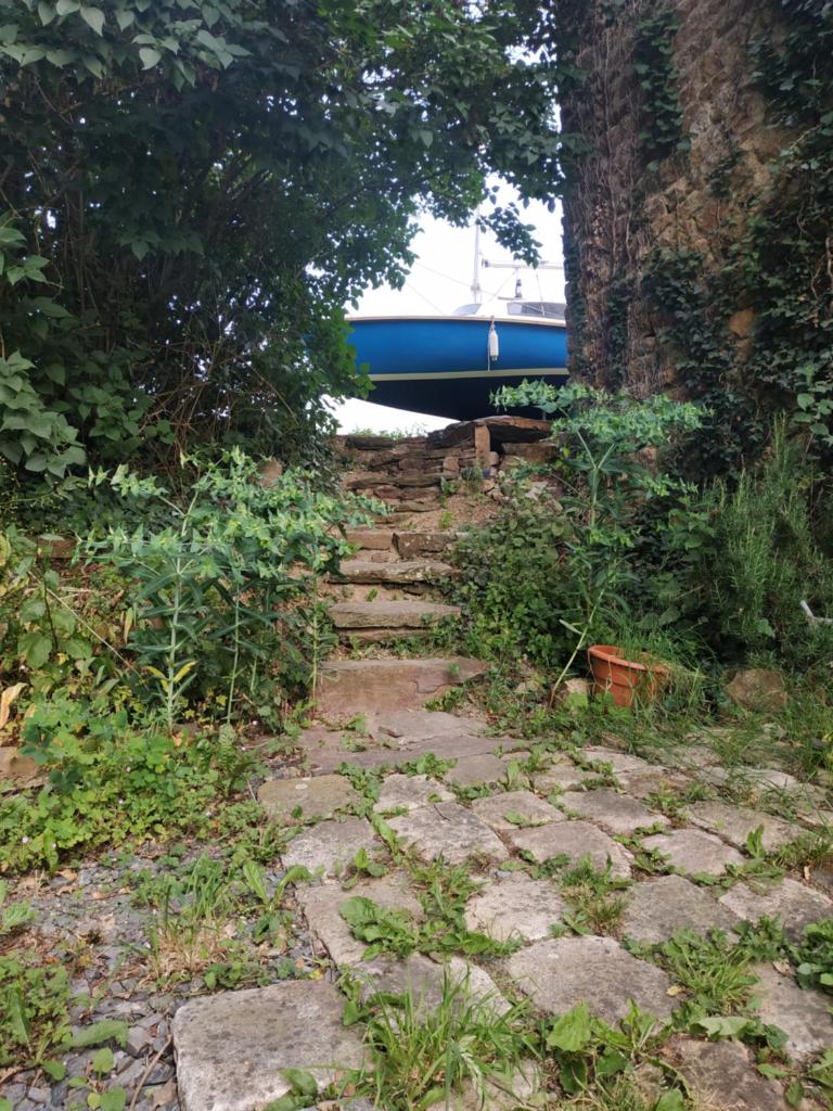 un chemin de pierre avec un bateau bleu en arrière-plan dans l'établissement Edel de la Touche Balard, à Val Couesnon 37 autres photos