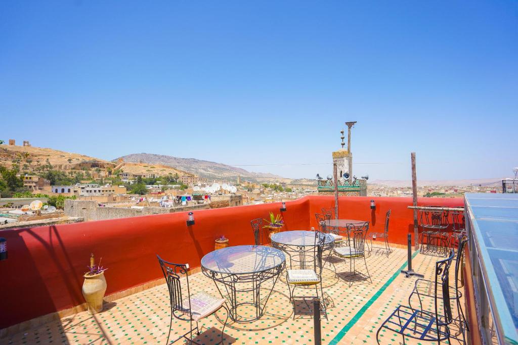 un patio avec tables et chaises sur un balcon dans l'établissement Riad Sahraui, à Fès