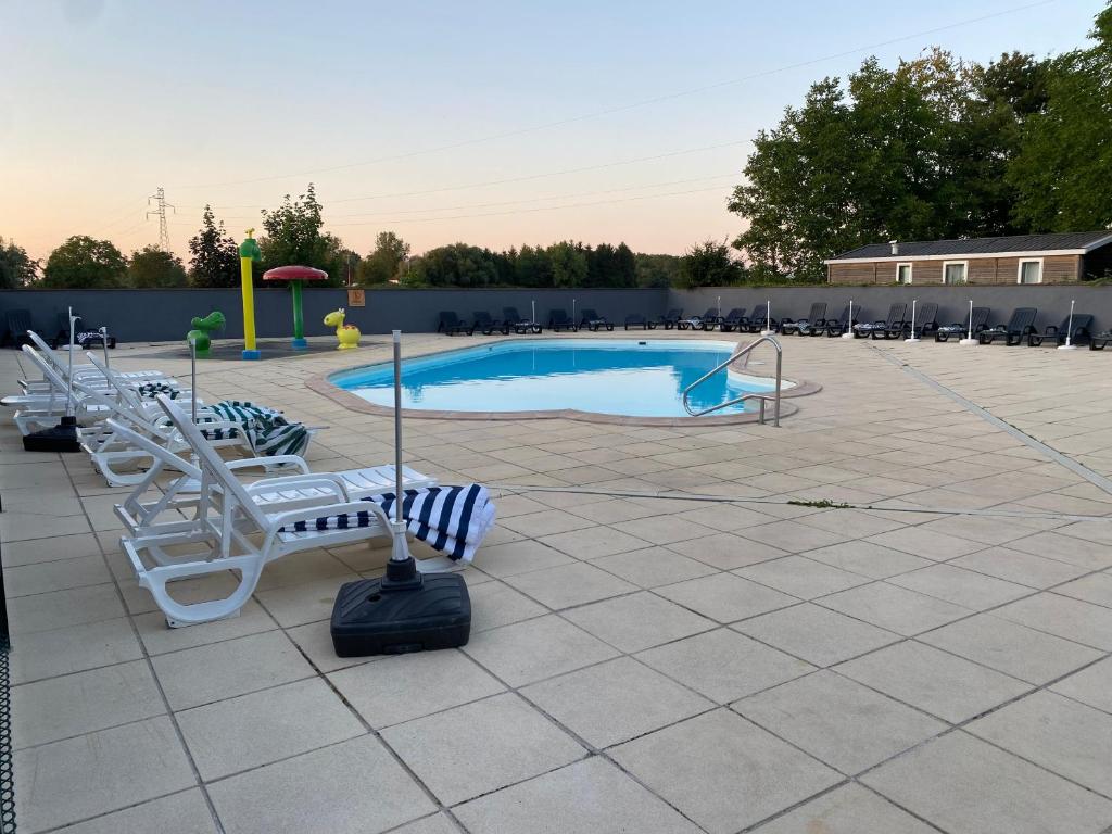 une piscine avec des chaises longues et une aire de jeux dans l'établissement MORREALE MOBILE HOME (prox. Europa park/Rulantica), à Boofzheim