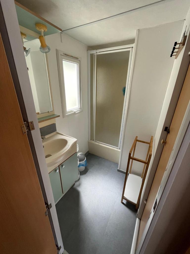 une salle de bain avec un lavabo, des toilettes et un miroir dans l'établissement Mobile home camping Pedro, au Grau-dʼAgde