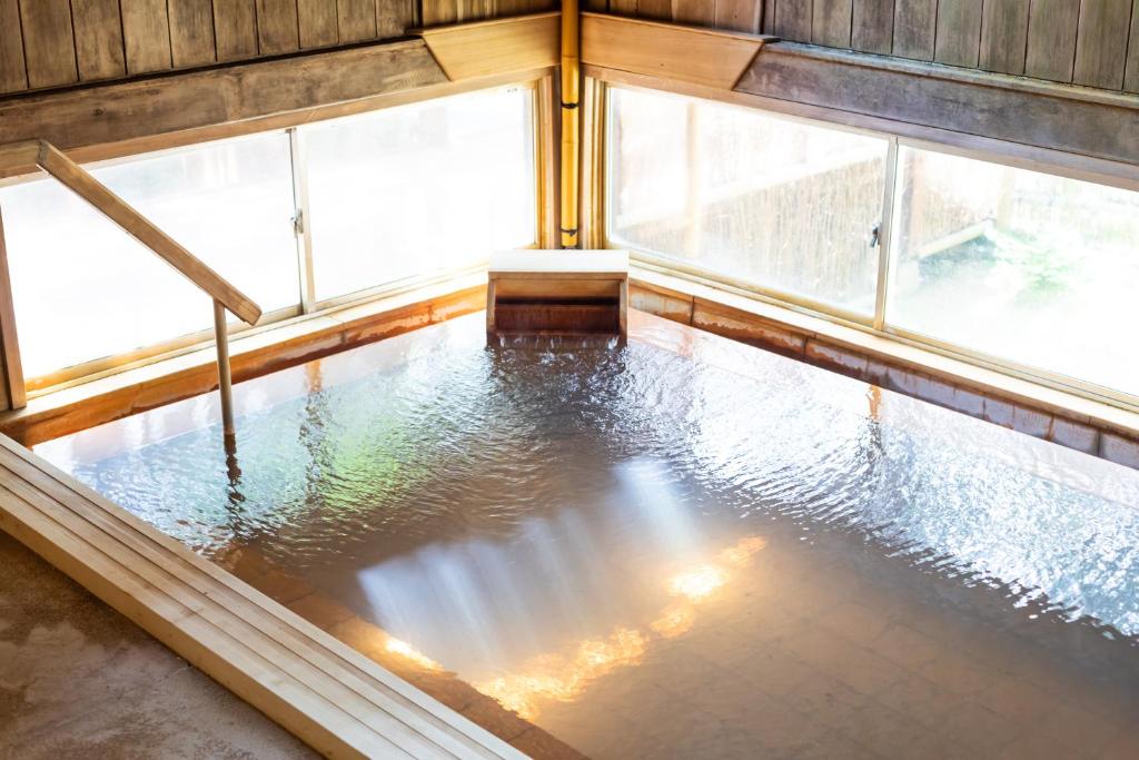 Cette chambre avec fenêtres offre une vue sur la piscine d'eau. dans l'établissement Hirayukan, à Takayama