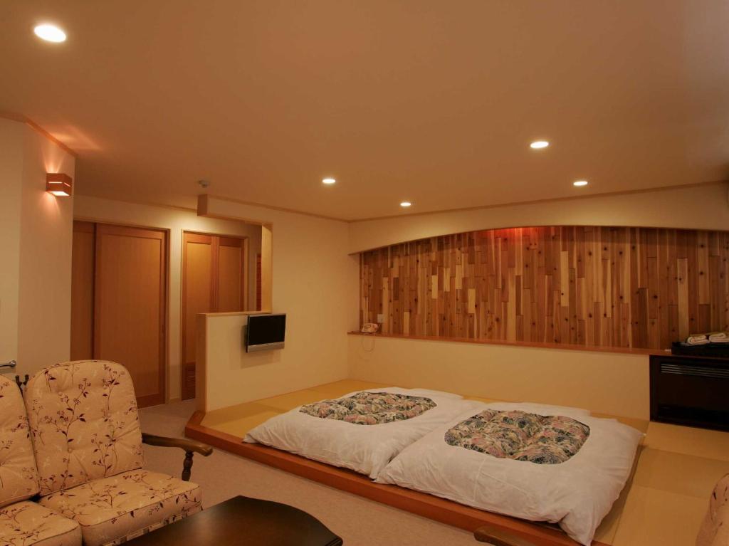 une chambre avec un lit, un canapé et une chaise dans l'établissement Nakaodaira, à Takayama