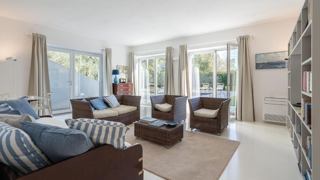 - un salon avec des canapés, des chaises et des fenêtres dans l'établissement Villa Giomoa 8, Emma Villas, à Capoliveri