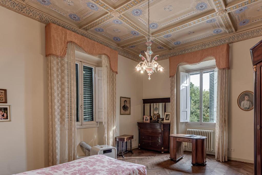 une chambre avec un lit et un lustre dans l'établissement Villa Bruschetti, à Empoli
