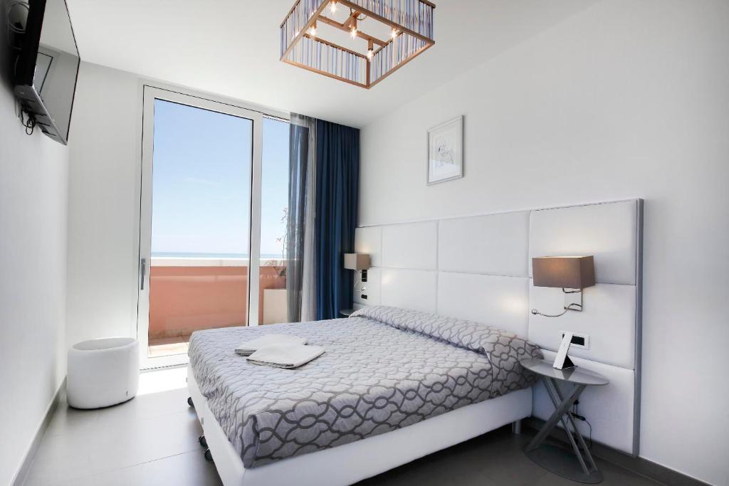 une chambre avec un lit et une grande fenêtre dans l'établissement Grande Albergo Marin, à Lignano Sabbiadoro 30 autres photos