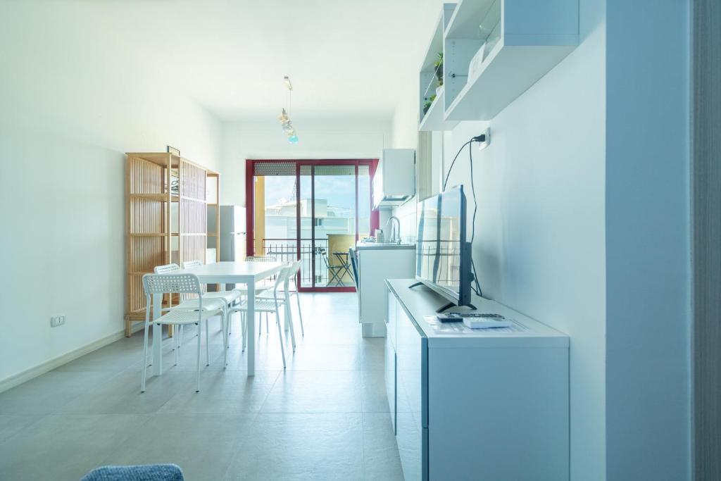 une cuisine avec une table et des chaises dans une pièce dans l'établissement Appartamenti Craulo, à Otrante