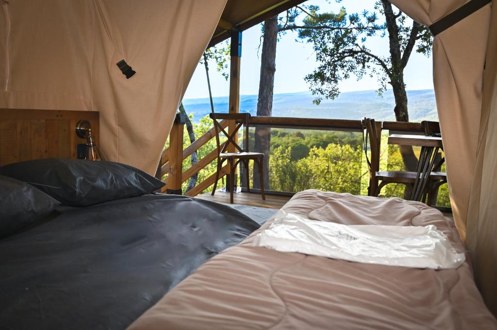 - un lit installé à l'intérieur d'une tente avec balcon dans l'établissement Camping le Colorado, à Rustrel 37 autres photos