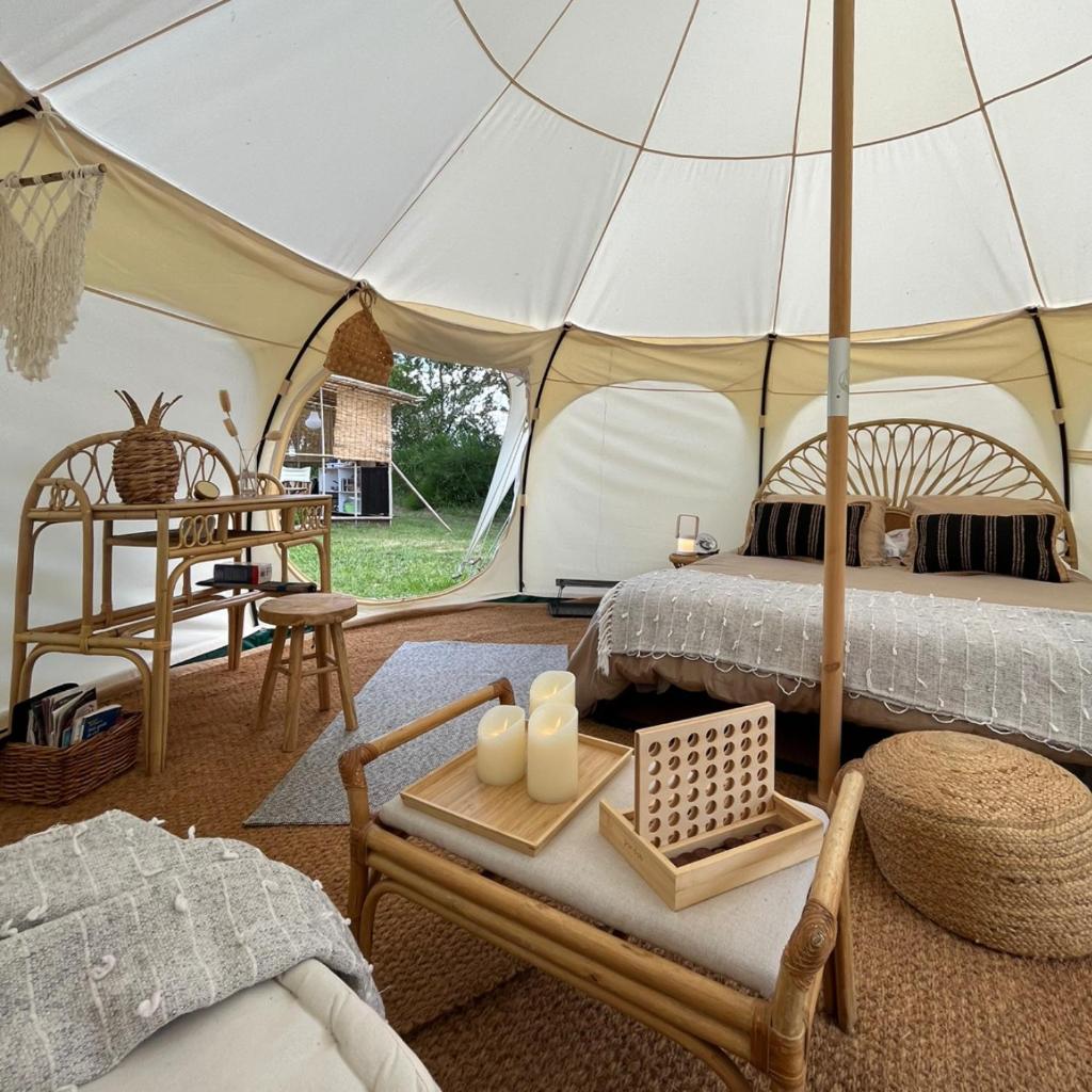 une tente avec un lit et une table avec des bougies dans l'établissement La Prairie Étoilée Luxury Glamping - Adults Only, à Crozon-sur-Vauvre
